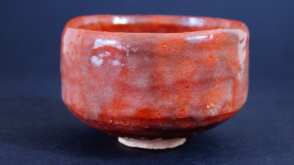 Otra vista lateral del chawan de cerámica Raku de Sairi Hotoku con esmalte rojo tornasolado