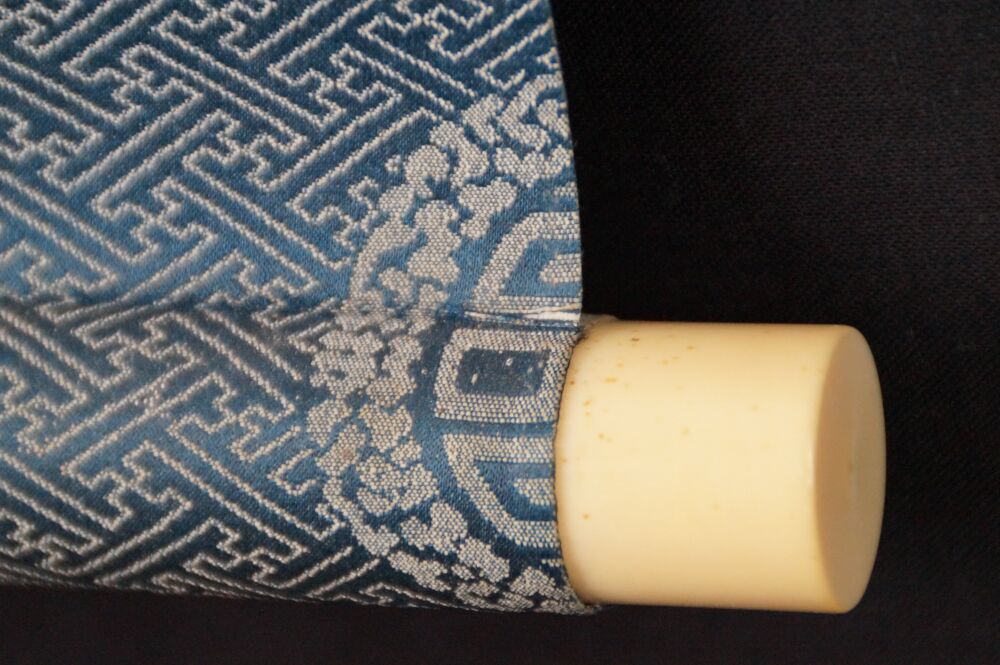 Detailansicht des Rollenendes mit Elfenbeinknauf und blauer Brokat-Seide des Kakemono Japanische Aubergine