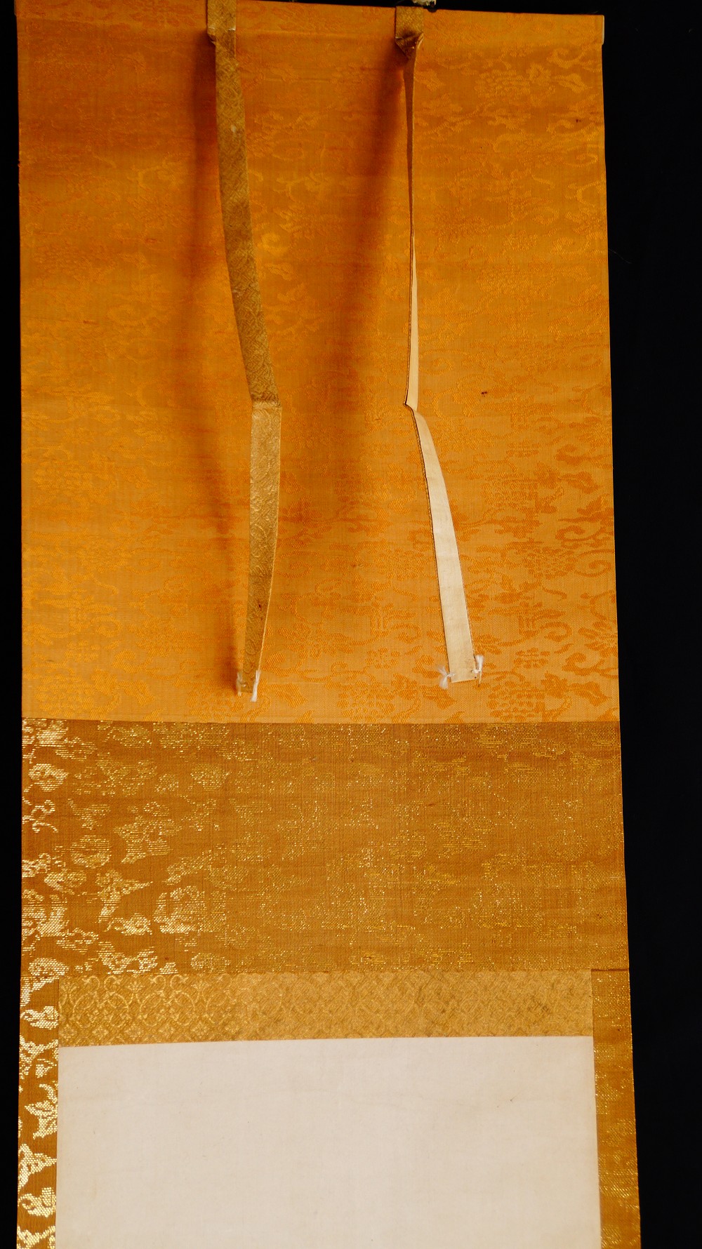 Detail der Montierung des Kakemono mit goldbraunem Brokat und Aufhaengebaendern