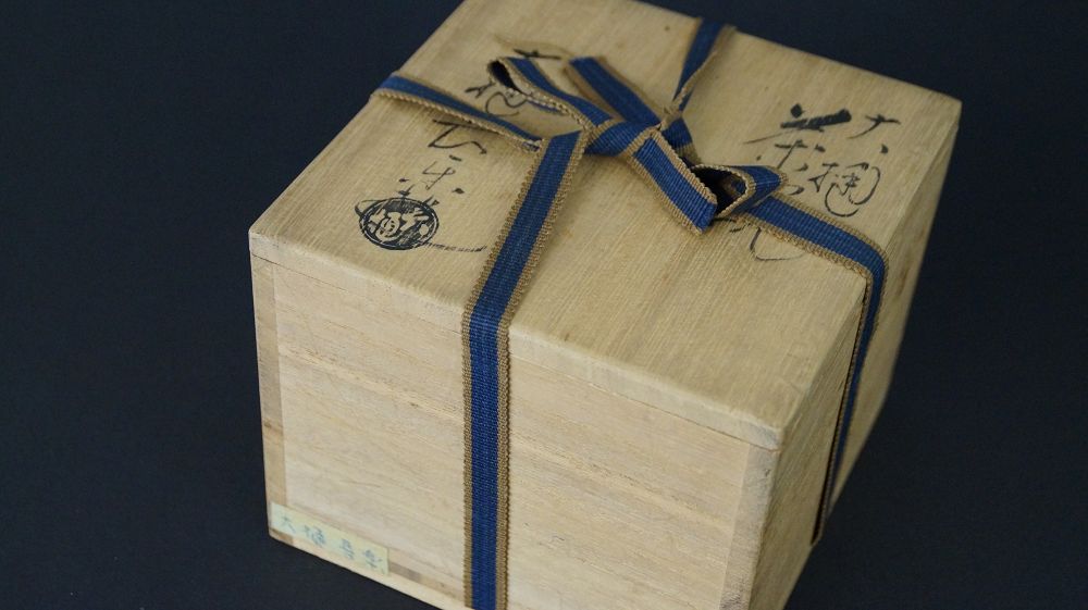 Geschlossene, mit blauem Band verschnuerte Aufbewahrungsbox der Chawan Teeschale aus Ohi-Keramik