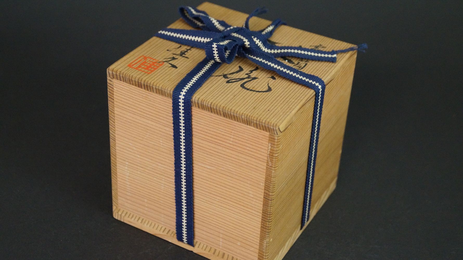 Geschlossene, mit blau-weissem Band verschnuerte Aufbewahrungsbox der Chawan Teeschale aus Kyoto-Keramik