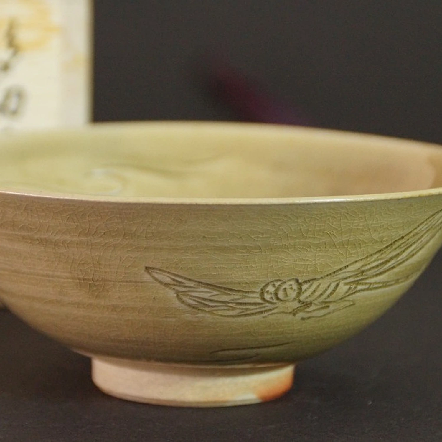 Chawan con motivo de libélula ante la caja de conservación visible desenfocada