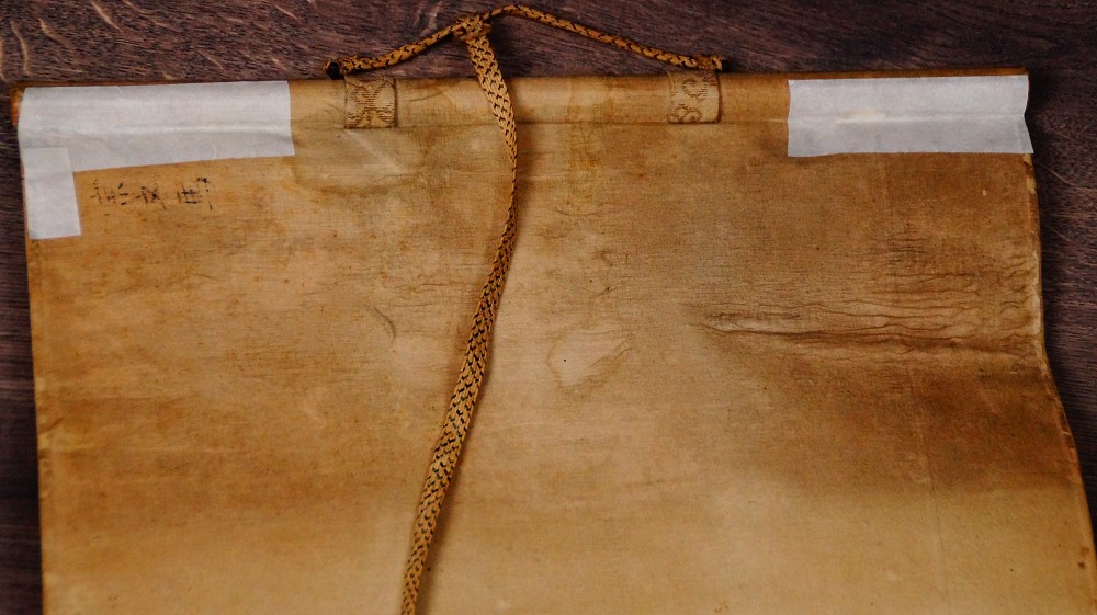 Detail der oberen Montierung mit Aufhaengeschnur und Beschriftungsetikett des Kakemono