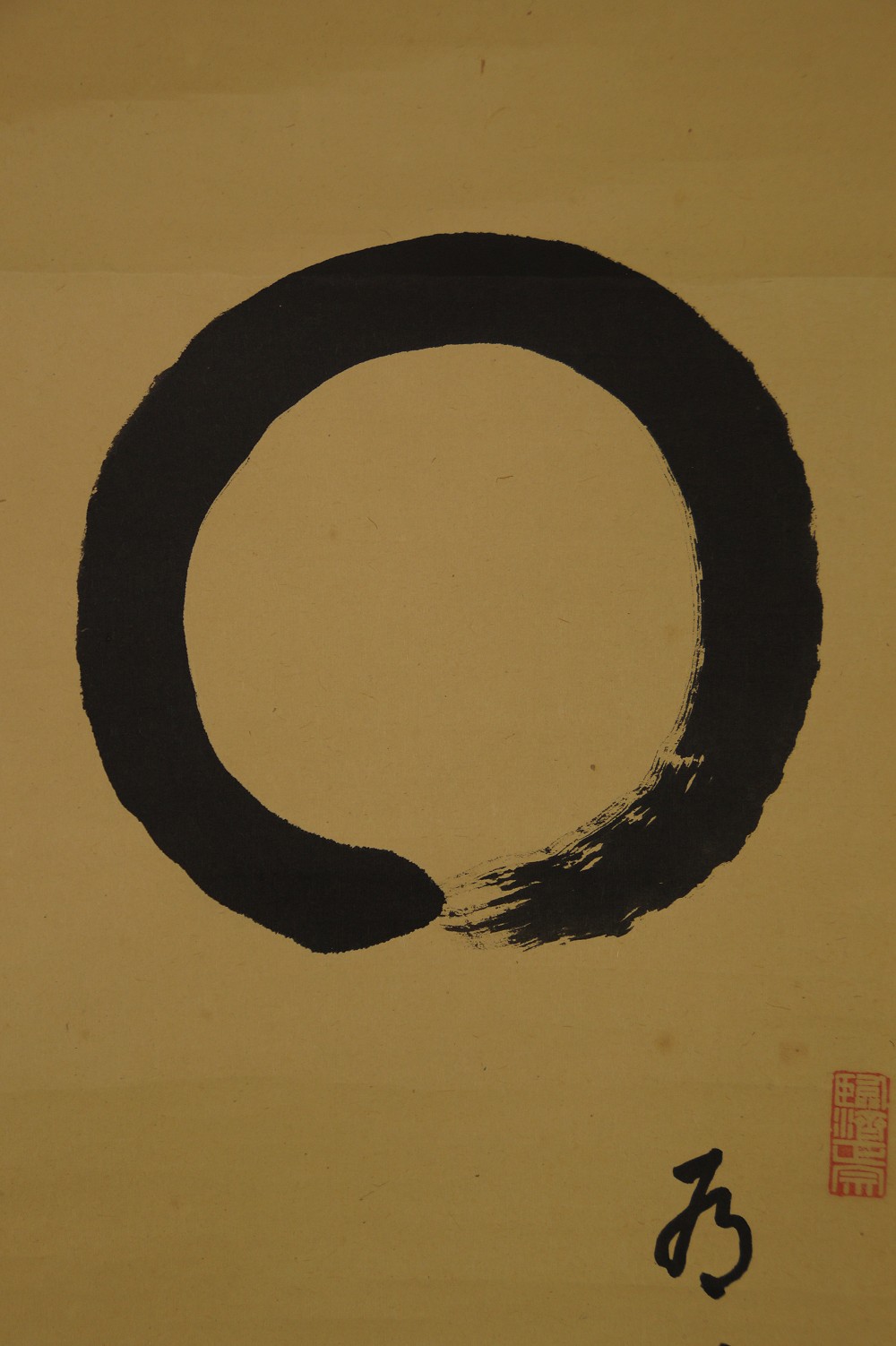Nahaufnahme des Enso-Kreises mit kleinem Schriftzeichen und rotem Siegel