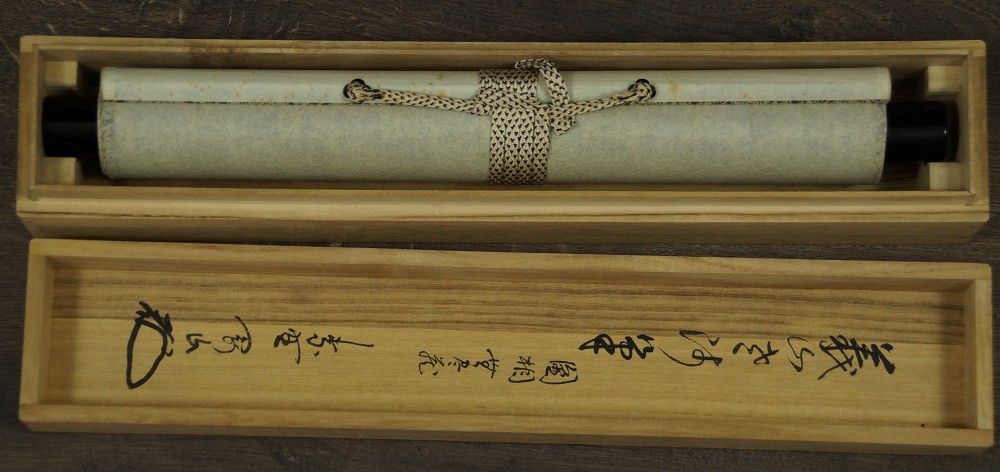 Zusammengerolltes Kakemono in der beschrifteten Aufbewahrungsbox mit Kordel