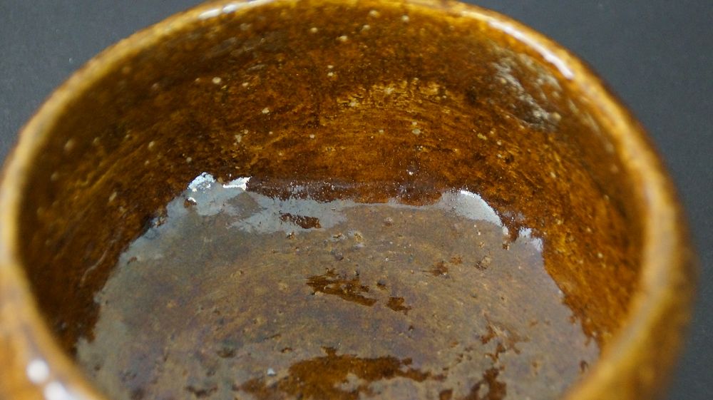 Nahaufnahme der braun gesprenkelten Innenglasur der Chawan Teeschale aus Raku-Keramik
