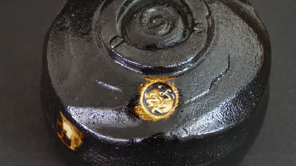 Vista de detalle del pie con el sello del artista grabado del cuenco de té de cerámica Raku