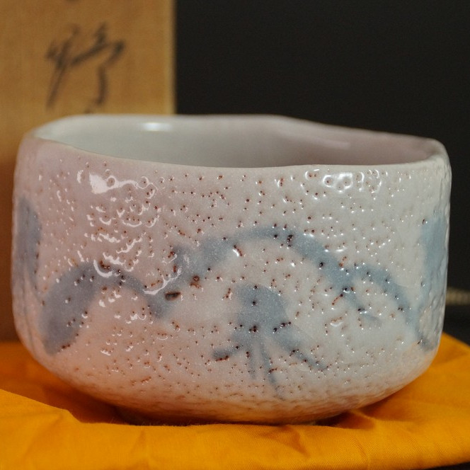 Chawan aus Shino-Keramik vor der unscharf sichtbaren Aufbewahrungsbox