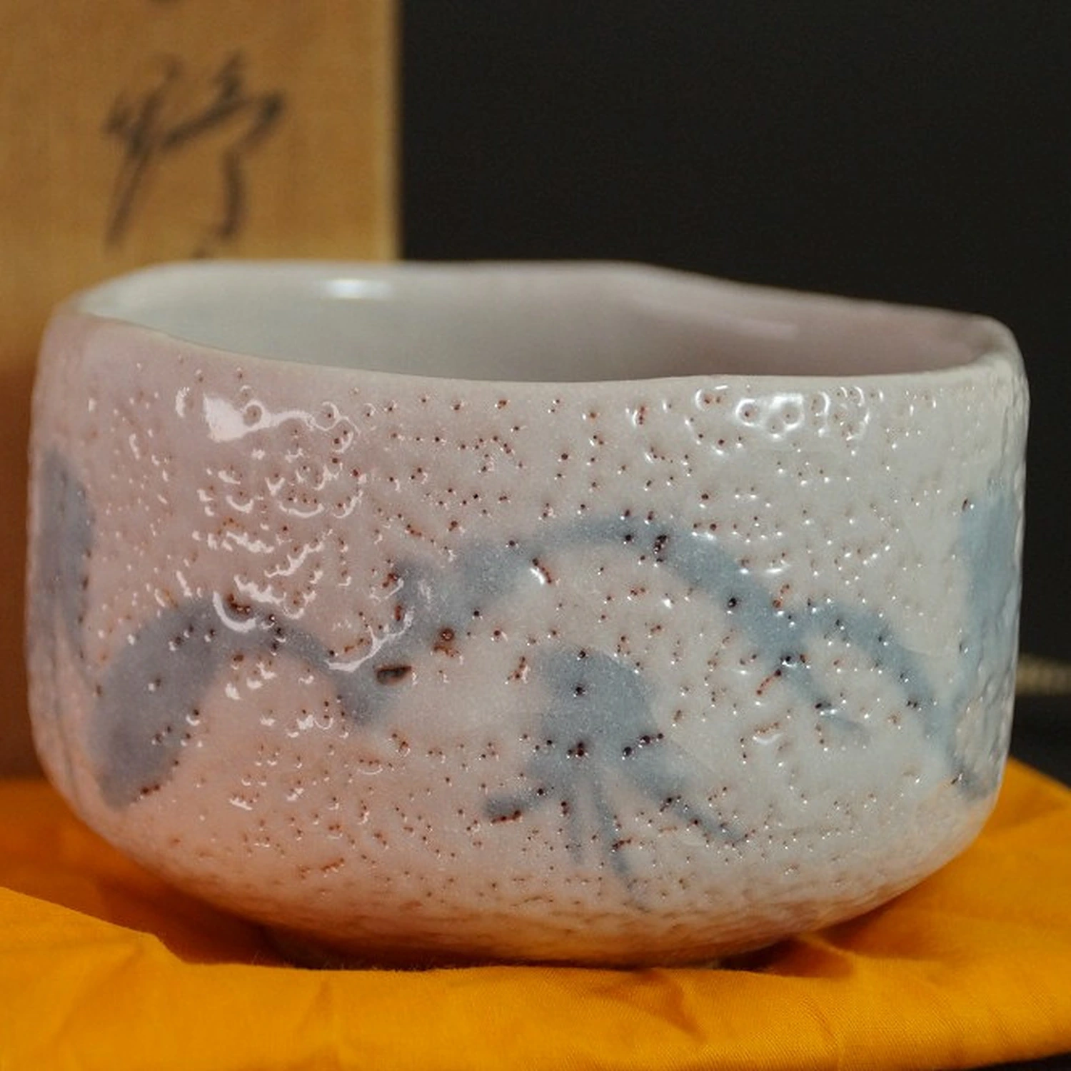 Chawan de cerámica Shino ante la caja de conservación visible de forma difusa