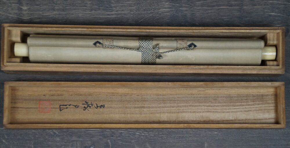 Geoeffnete Aufbewahrungsbox mit zusammengerolltem Kakemono Hahn und Pflaumenblueten