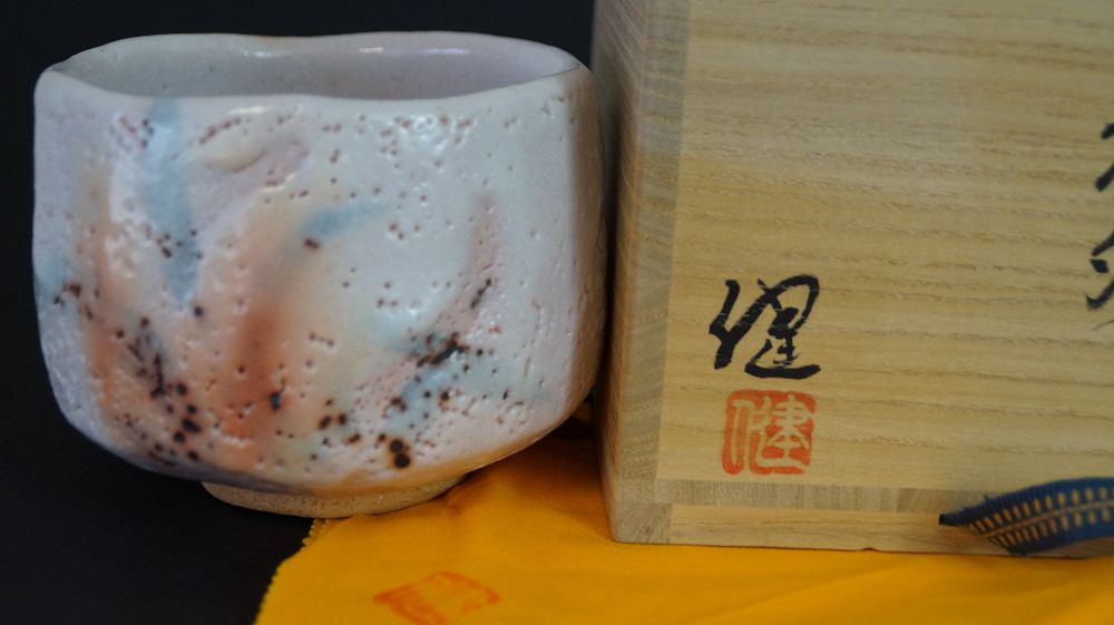 Chawan aus Shino-Keramik neben der signierten Aufbewahrungsbox mit rotem Kuenstlersiegel