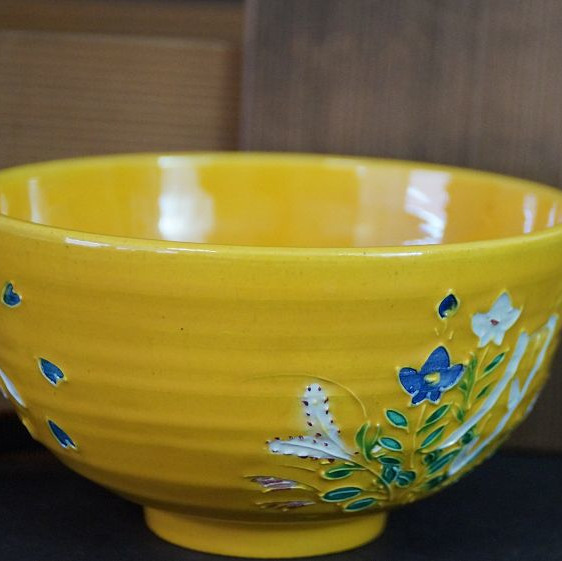 Chawan aus Kyoto-Keramik von Roseki Akazawa in der Gesamtansicht mit leuchtend gelber Glasur und bemaltem Blumenmotiv