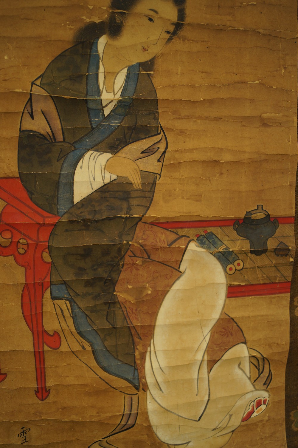 Red table with book and incense burner motif close-up