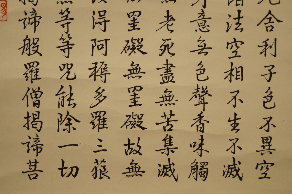 Ink calligraphy sutra text with red seal at the edge brushwork close-up 1