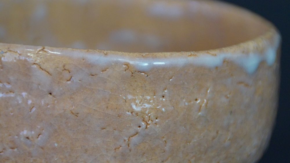 Primo piano del bordo con smalto craquelé e gocce di smalto della chawan in ceramica di Hagi