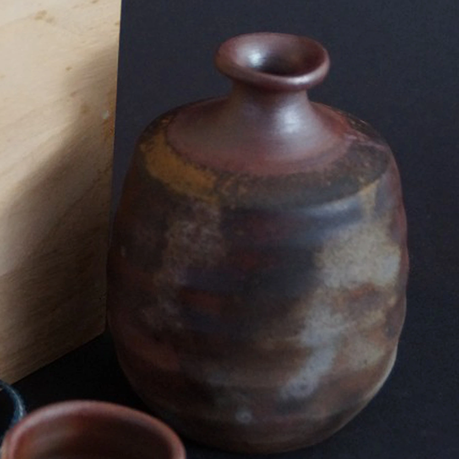 Vista previa en primer plano de la botella de sake de Bizen con la caja de conservación al fondo