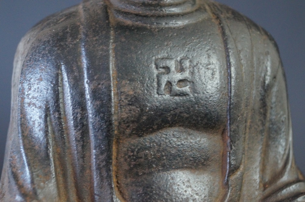 Japanische Buddhafigur aus Eisen Manji-Symbol Nahaufnahme