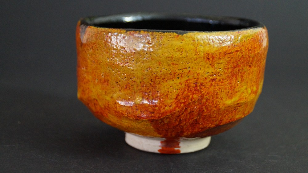 Vue de côté du chawan en céramique de Tobe avec glaçure ambrée et bord intérieur noir, par Haryoku