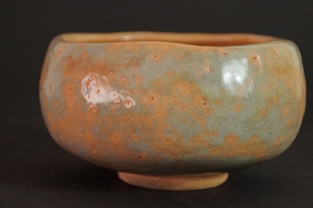 Vista laterale del chawan con gioco cromatico fluido di arancione e verde