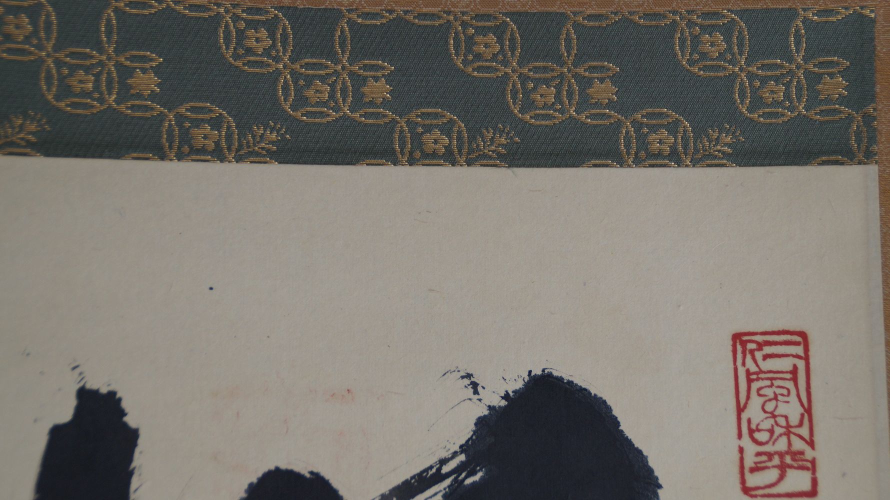 Vue detaillee de la montage en brocart vert avec motif dore au bord superieur de l'image du kakemono Calligraphie zen Mu Vacuite