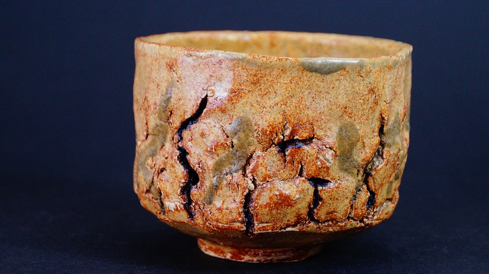 Chawan aus Seto-Keramik von Takamichi Kato in der Frontalansicht mit ockerfarbener, tief rissiger Glasur