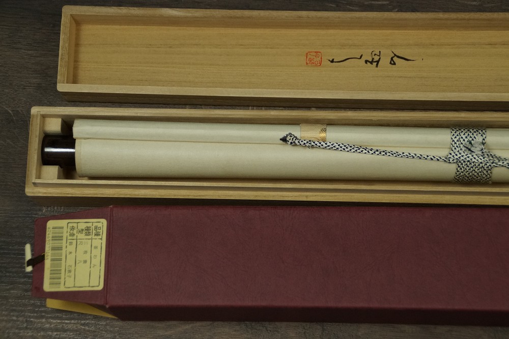 Zusammengerolltes Kakemono in der Aufbewahrungsbox mit keramischem Jikusaki