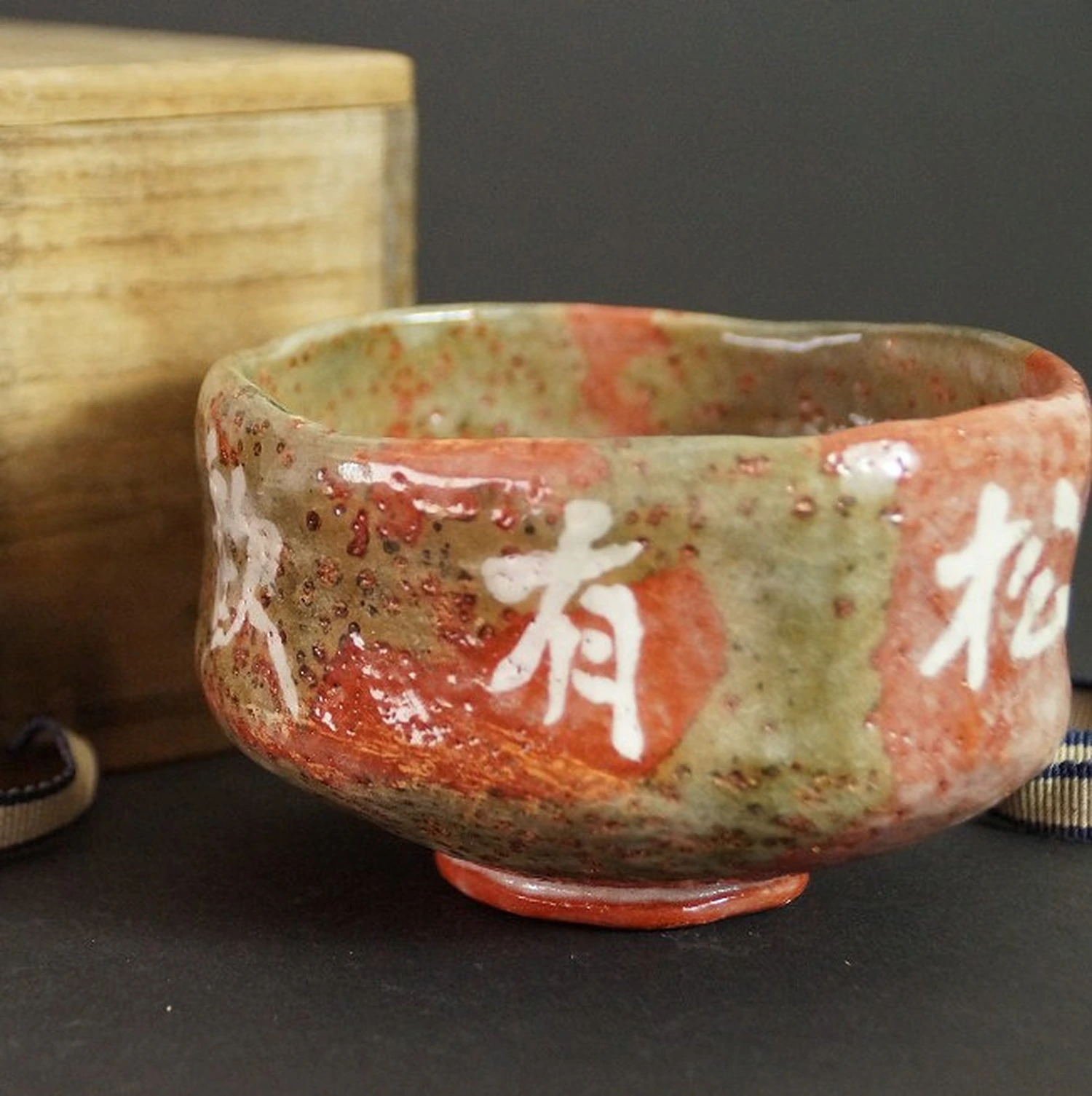 Chawan con caratteri nello smalto davanti alla scatola di conservazione visibile sfocata
