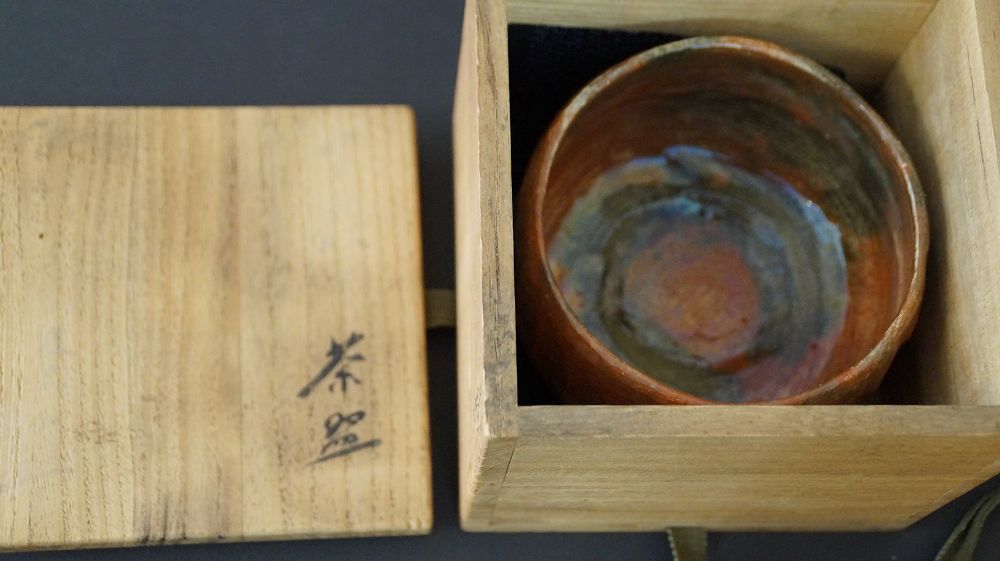 Chawan Teeschale in der geoeffneten Aufbewahrungsbox mit der Aufschrift Chawan aus Raku-Keramik