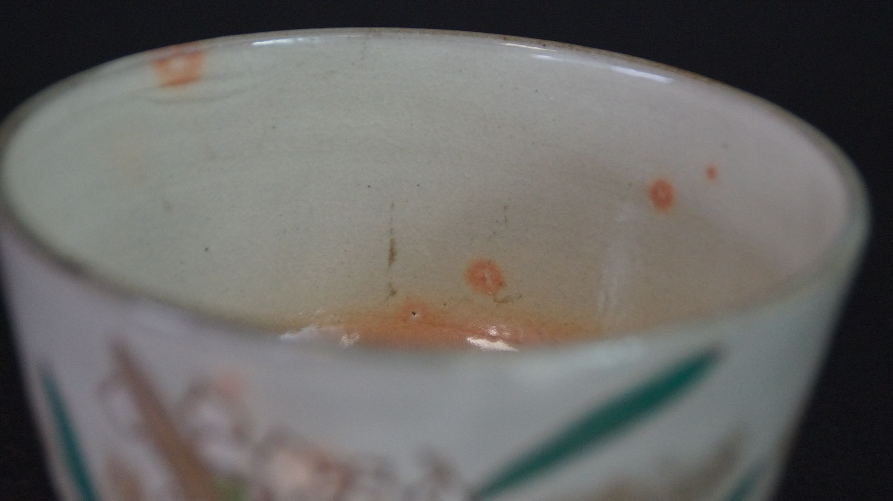 Nahaufnahme der cremefarbenen Innenglasur mit orangefarbenen Punkten der Chawan Teeschale aus Kyoto-Keramik