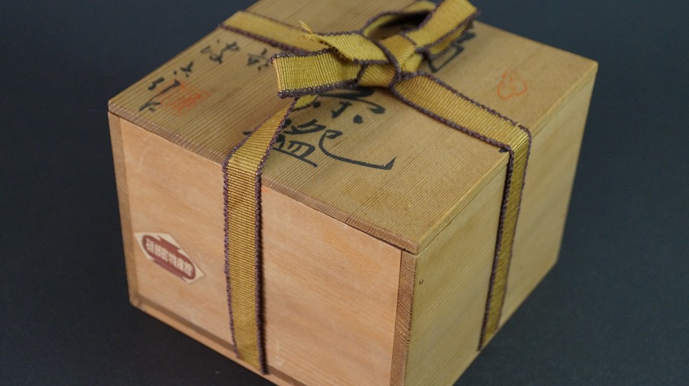 Boîte de rangement fermée en bois de kiri avec cordon de fermeture doré et inscription à l'encre