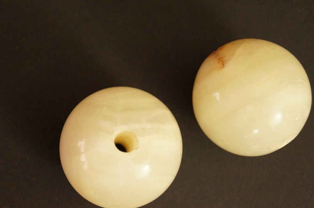 Due sfere di pietra naturale chiara, una con venatura rosso-bruna, primo piano pietra 4