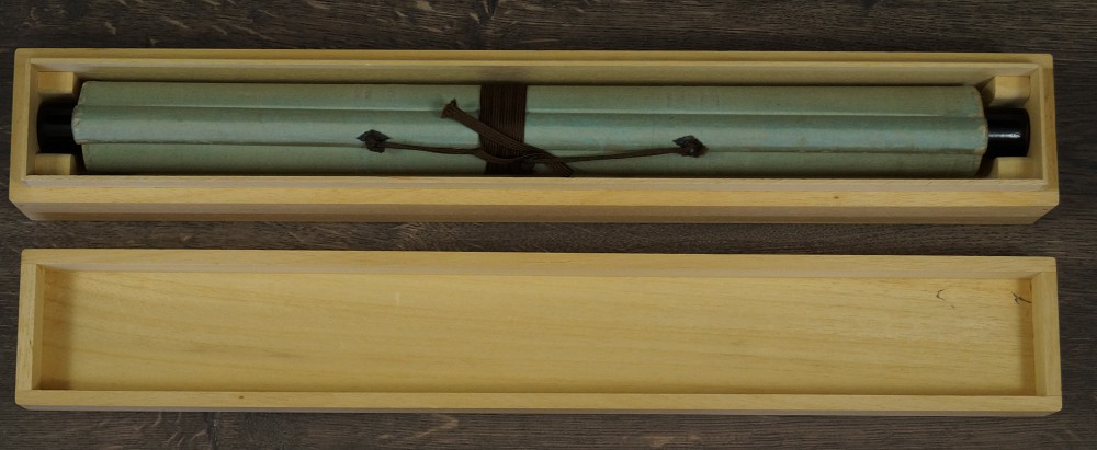 Zusammengerolltes Rollbild in geoeffneter Holzbox mit Kordel Kakemono in Aufbewahrungsbox