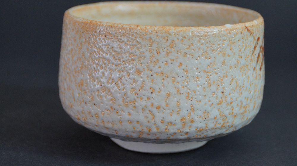 Rueckseite der Chawan aus Shino-Keramik mit oranger Feuerspur auf weisser Glasur