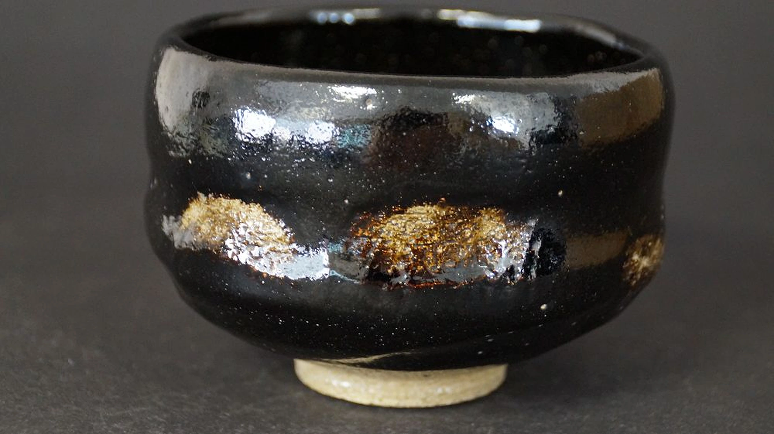 Autre vue du chawan en céramique Raku avec glaçure noire brillante et touches dorées