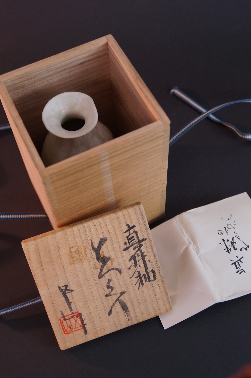 Die Sake Flasche stehend in der geoeffneten Aufbewahrungsbox mit Echtheitszertifikat