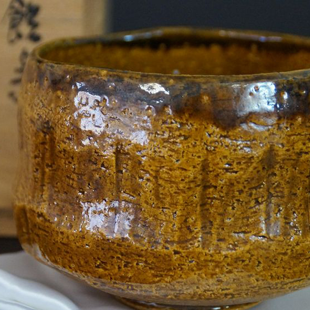 Chawan aus Raku-Keramik von Rakunyu Yoshimura mit honigfarbener Ame-Glasur vor der Aufbewahrungsbox
