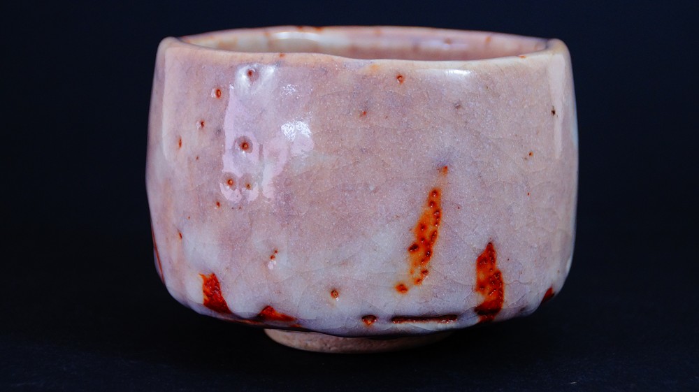 Chawan aus Shino-Keramik von Masayoshi Kato in der Frontalansicht mit lachsfarbener Glasur und roten Feuerspuren
