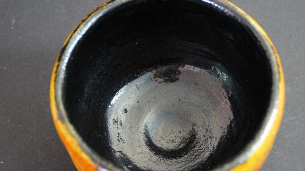 Gros plan de la glaçure brillante noire au fond du chawan par Haryoku