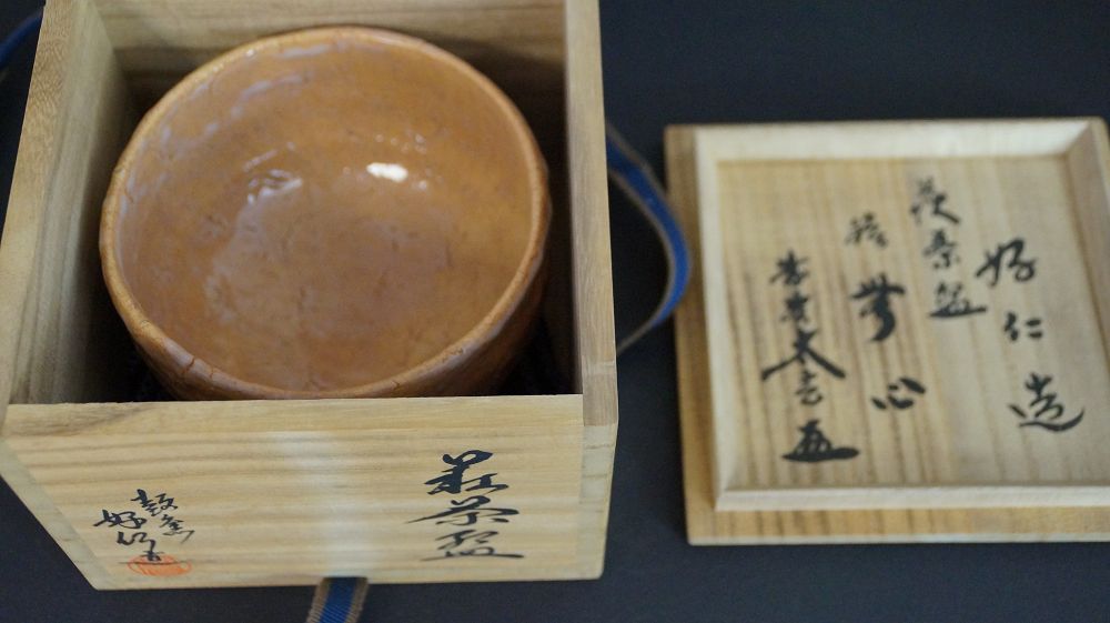 Chawan in ceramica di Hagi nella scatola di conservazione aperta accanto al coperchio della scatola con etichetta