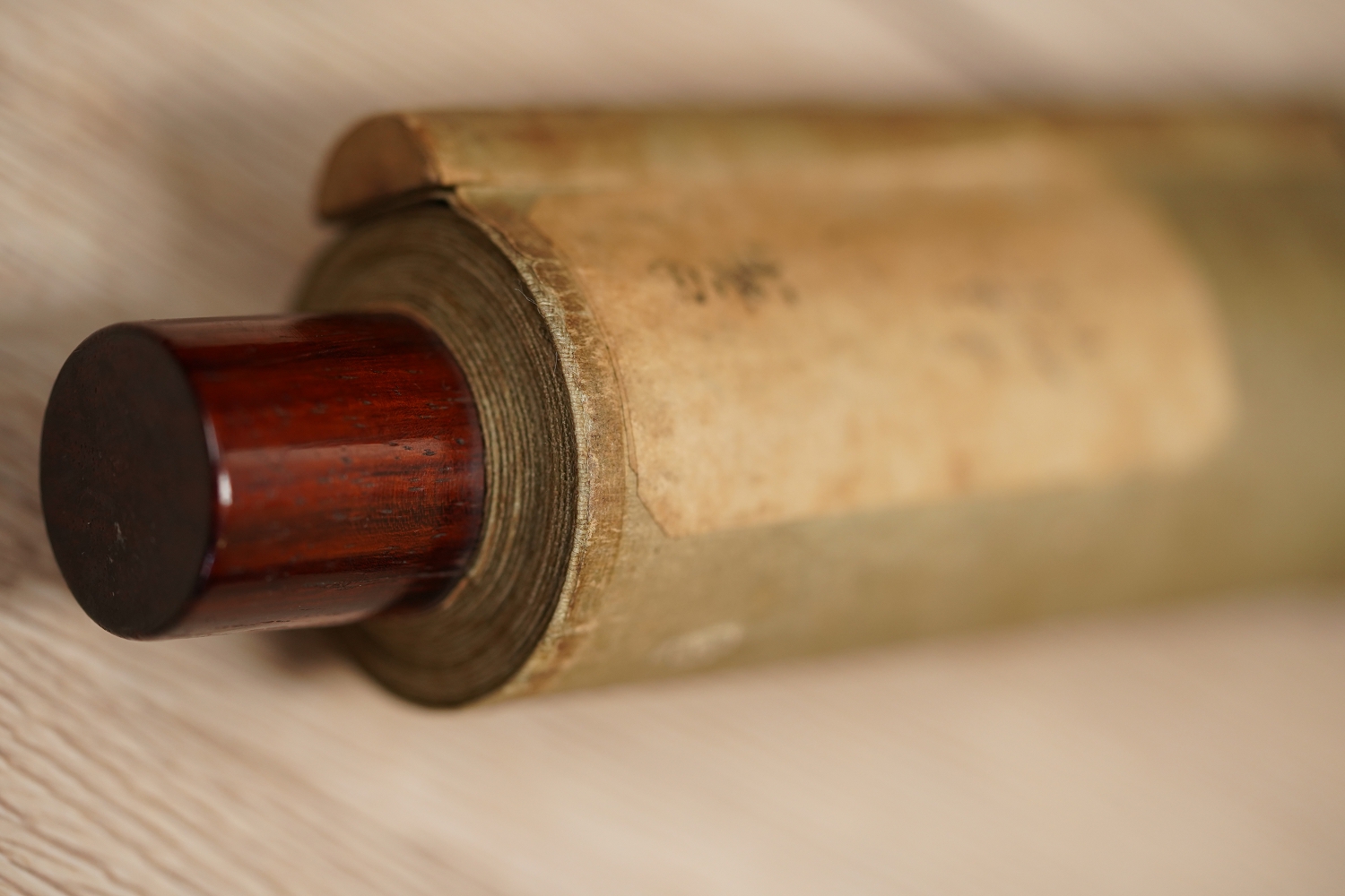 Detailansicht des Rollenendes mit dunkelrotem Lackknauf und cremefarbener Seide des Kakemono Singvogel auf bluehendem Pflaumenbaum