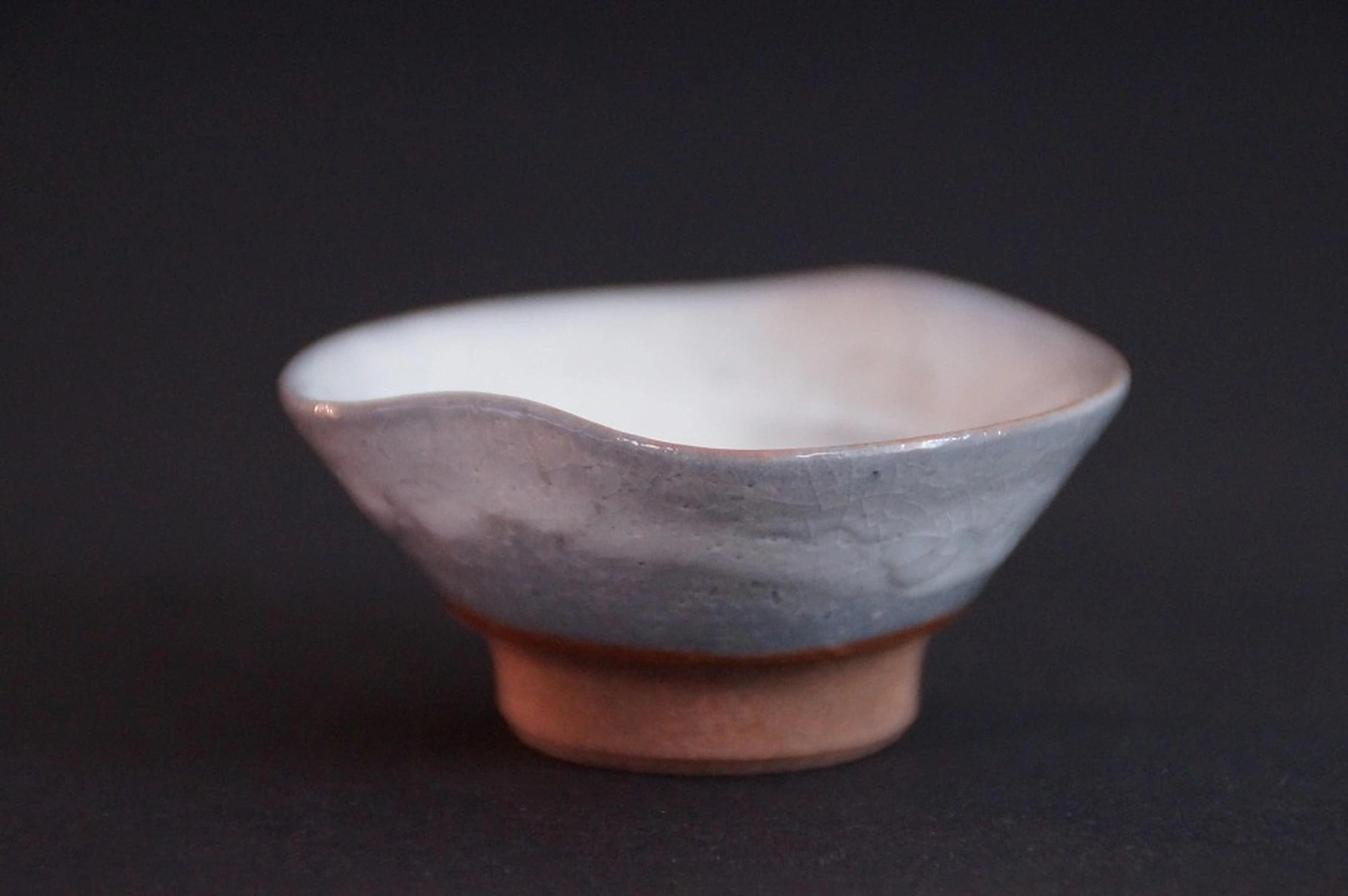 Front view of the handcrafted Seto sake cup with wavy rim