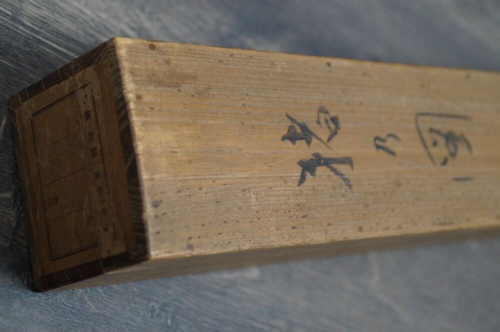 Deckel der Aufbewahrungsbox mit Kalligraphie-Beschriftung und Papieretikett des Kakemono Wildschwein im Herbstlaub