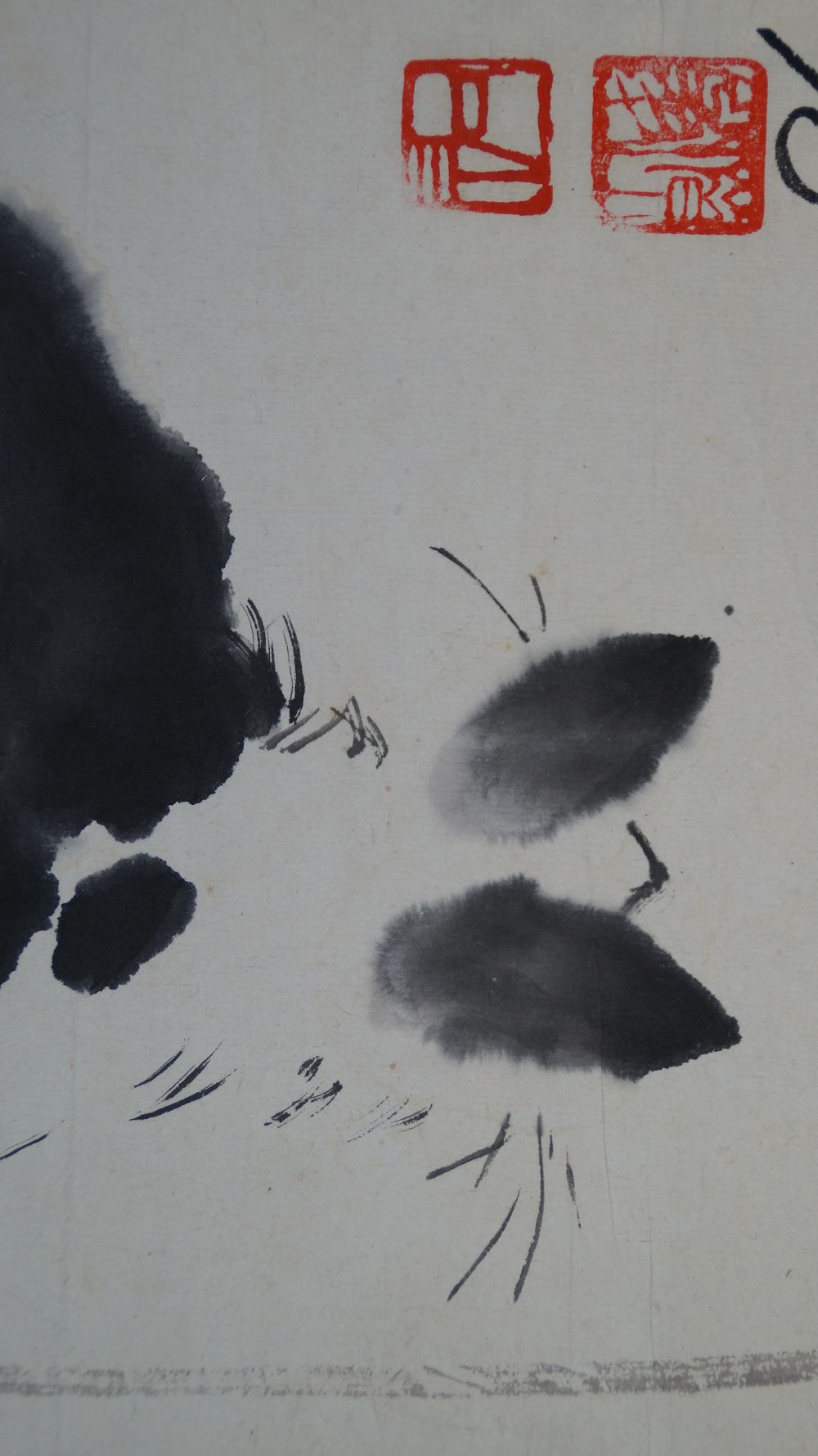 Gros plan des deux sceaux rouges de l'artiste au-dessus des oreilles du chat noir