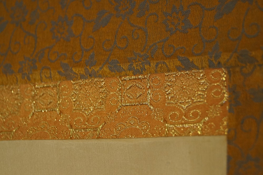 Eckdetail der goldfarbenen Brokatmontierung mit Blumenmuster Montierungsdetail