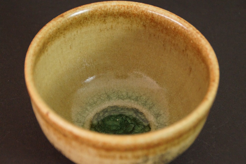 Nahaufnahme der gruen gesprenkelten Glasur im Inneren des Chawan