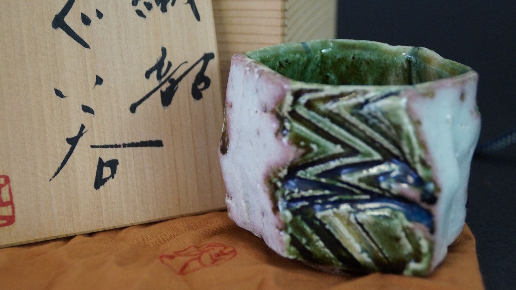 Guinomi Sake-Schale aus Oribe-Keramik neben der signierten Aufbewahrungsbox mit rotem Kuenstlersiegel