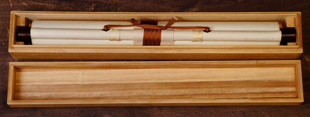 Zusammengerolltes Kakemono in der geoeffneten Aufbewahrungsbox mit Verschnuerung