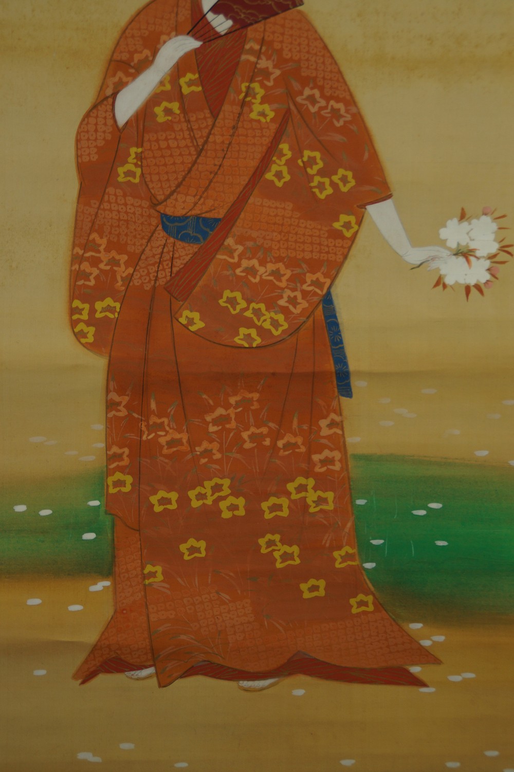 Nahaufnahme des kunstvoll gemusterten orangefarbenen Kimono mit blauem Obi