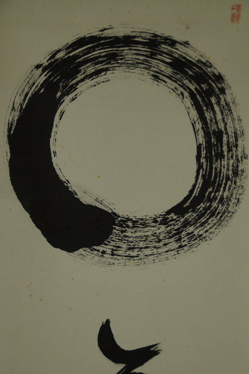 Nahaufnahme des Enso-Kreises mit dem ersten Schriftzeichen darunter
