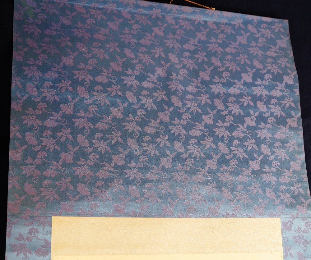 Detalle del montaje del kakemono con brocado de flores azul violáceo